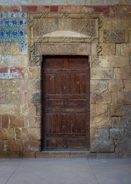 Old wooden door framed by bricks stone wall at the courtyard of al Razzaz historic house, Darb al Ahmar district, Old Cairo, Egypt