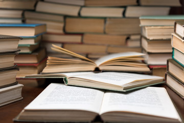 Open book on wood desk in the library room with blurred focus for education background and back to school concept