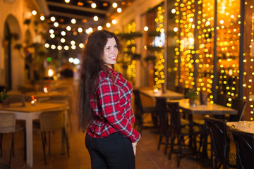 Beautiful young woman in a red shirt on a background of a night city