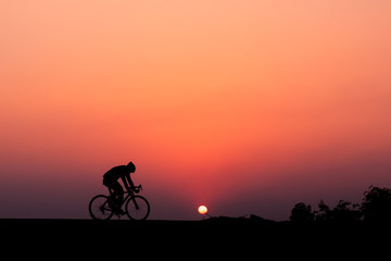 Obraz na płótnie Canvas ride a bicycle ,silhouette background.