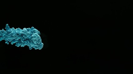 Super slow motion of coloured inks in water. Isolated on black background. Filmed on high speed cinema camera.