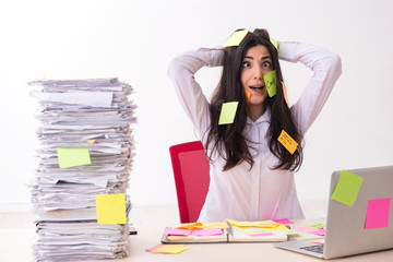 Young female employee in conflicting priorities concept 