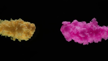 Super slow motion of coloured inks in water. Isolated on black background. Filmed on high speed cinema camera.