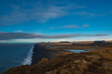 Fototapeta na wymiar View of the black beach and the mountains from the cliff Dyrholaey. Iceland.