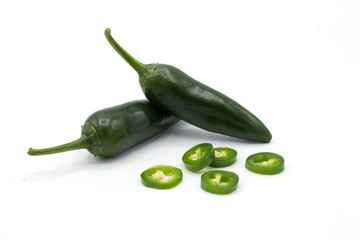green peperonis on a white background