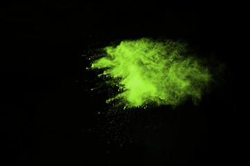 The movement of abstract dust explosion frozen green on black background. Stop the movement of powdered green on black background. Explosive powder green on black background.