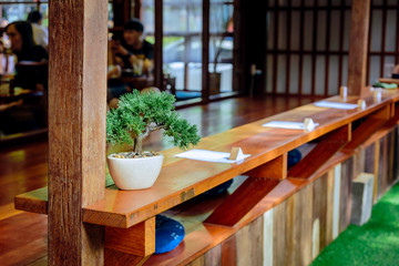 Japanese bar at the cafe or restaurant with a little green plant and paper for note made from wood