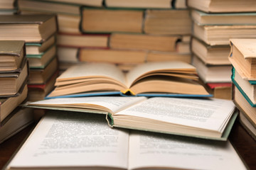 Open books on wood desk in the library room with blurred focus for education background and back to school concept