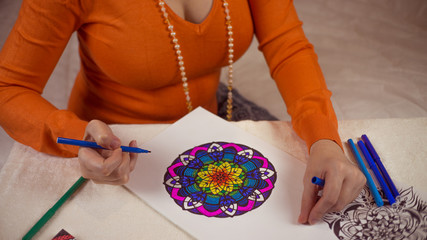 The girl draws a mandala
