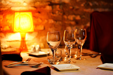 Restaurant table with a set of empty glasses and a lamp