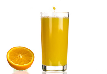 Pouring orange juice into a transparent glass on a white background