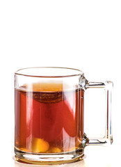 Making tea with sugar from a tea bag in a transparent mug on a white background