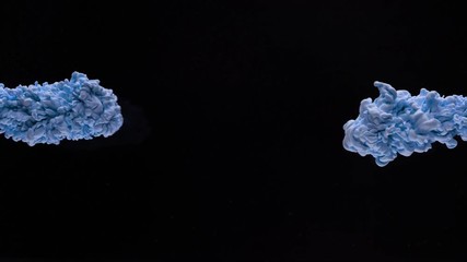 Super slow motion of coloured inks in water. Isolated on black background. Filmed on high speed cinema camera.