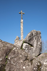 Antique stone cross on big granite rocks