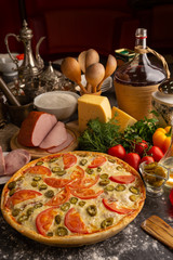 Pizza with ham, tomatoes and jalapeno peppers.