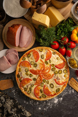 Pizza with ham, tomatoes and jalapeno peppers.