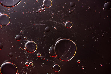 Beautiful macro photo of water droplets in oil with a black background.