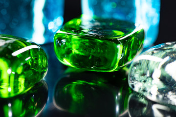 Macro photo of glass cubes of different colors on a black background with reflections