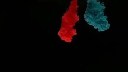 Super slow motion of coloured inks in water. Isolated on black background. Filmed on high speed cinema camera.