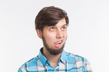 Obraz premium Expression, april fools day and joke concept - Young funny bearded man sticks his tongue out