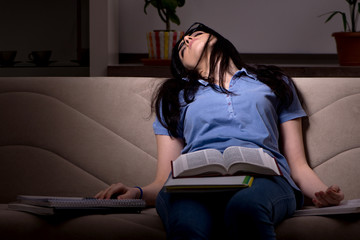 Obraz premium Young female student preparing for exams at night time 