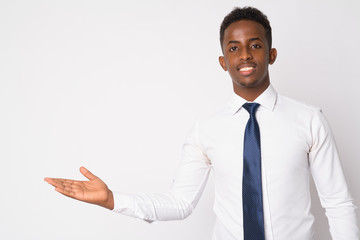 Portrait of happy young African businessman showing something