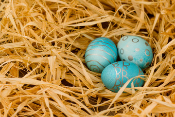 Easter eggs lie in the hay. Holiday concept