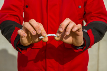 The guy breaks a cigarette. Anti nicotine concept. Stop smoking. World No Tobacco Day