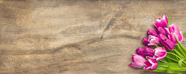 Frischer Tulpenstrauß auf großer eichefarbener Werbefläche aus historischem Holz
