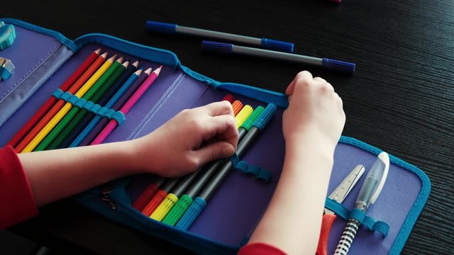 The girl makes pencils in school pencil case