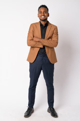 Full body shot of young happy African businessman smiling with arms crossed