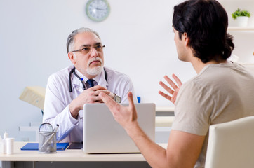 Obraz premium Young man visiting old male doctor 