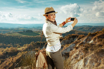 Fototapeta na wymiar happy fit tourist woman taking photo with smartphone