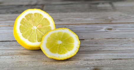 Freshly cut half lemons on a rustic wooden table.