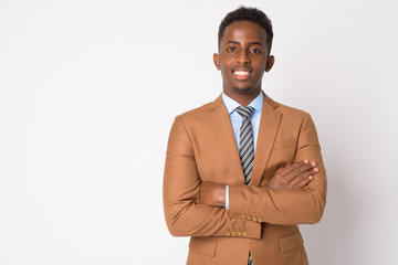 Portrait of young happy African businessman smiling with arms crossed