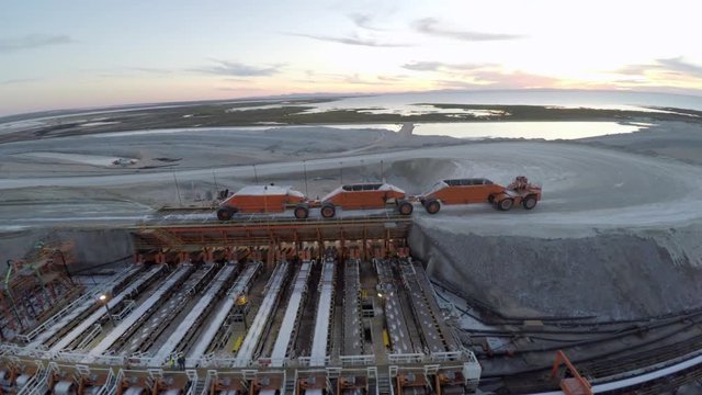 Aerial drone shot of a large truck unloading salt in the salt flats by solar evaporation in Guerrero Negro, Ojo de Liebre lagoon, Biosphere Reserve of El Vizcaino, Baja California Sur.
