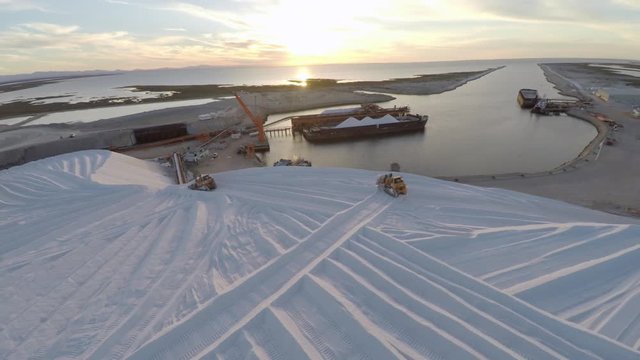 Aerial shot of tractors working on a large salt deposit in the salt flats by solar evaporation in Guerrero Negro, Ojo de Liebre lagoon, Biosphere Reserve of El Vizcaino, Baja California Sur.