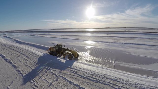 Aerial drone shot of a traktor separating salt to be harvested in the salt flats by solar evaporation in Guerrero Negro, Ojo de Liebre lagoon, Biosphere Reserve of El Vizcaino, Baja California Sur.