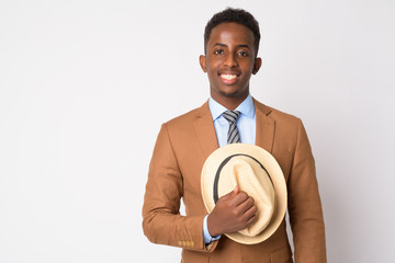 Portrait of young happy African businessman holding hat