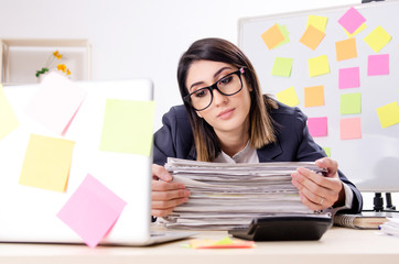 Young female employee in conflicting priorities concept 