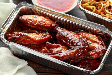 Chinese takeaway food. sweet and sour chicken wings, egg noodles with bean sprouts, chilli dip and prawn crackers