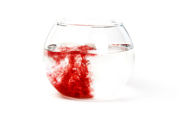 19.	The red liquid poured in the glass utensil, in transparent liquid. The mixing of different color liquids. The concept of medical theme on the isolated white background.