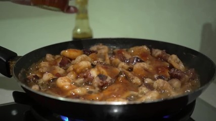Pouring seafood stewed in a frying pan with sauce.