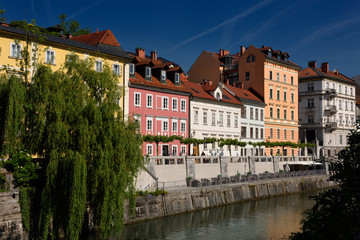 Bright pastel colors of renovated historic buildings Hribar Quay embankment of the Ljubljanica river canal waterway of Ljubjlana Slovenia