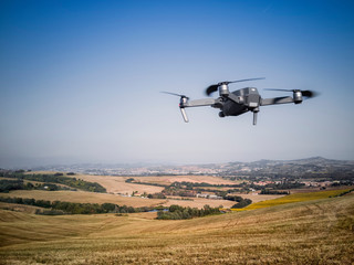 Fototapeta na wymiar Drone vola verso le colline con campi di grano e girasoli