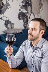 Man tasting a glass of red wine. Selective focus.