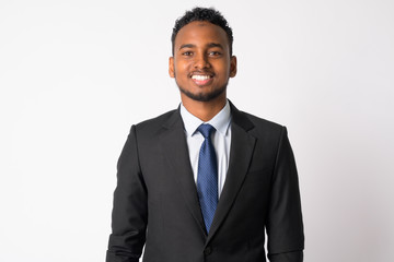 Happy young handsome African businessman in suit smiling