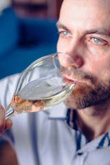 Man tasting a glass of white wine. Selective focus. 