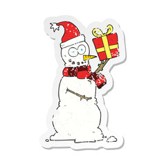retro distressed sticker of a cartoon snowman holding present