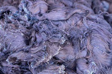 Fabric scraps, old clothing and textiles are cut into strips waiting for recycle.